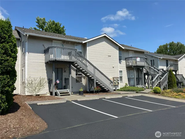a living room with furniture kitchen view and a large window