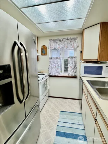 a kitchen with stainless steel appliances granite countertop a refrigerator and a stove