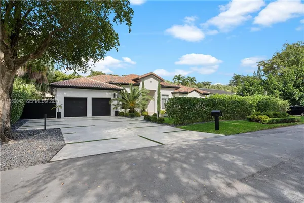 a front view of a house with yard garage and outdoor seating