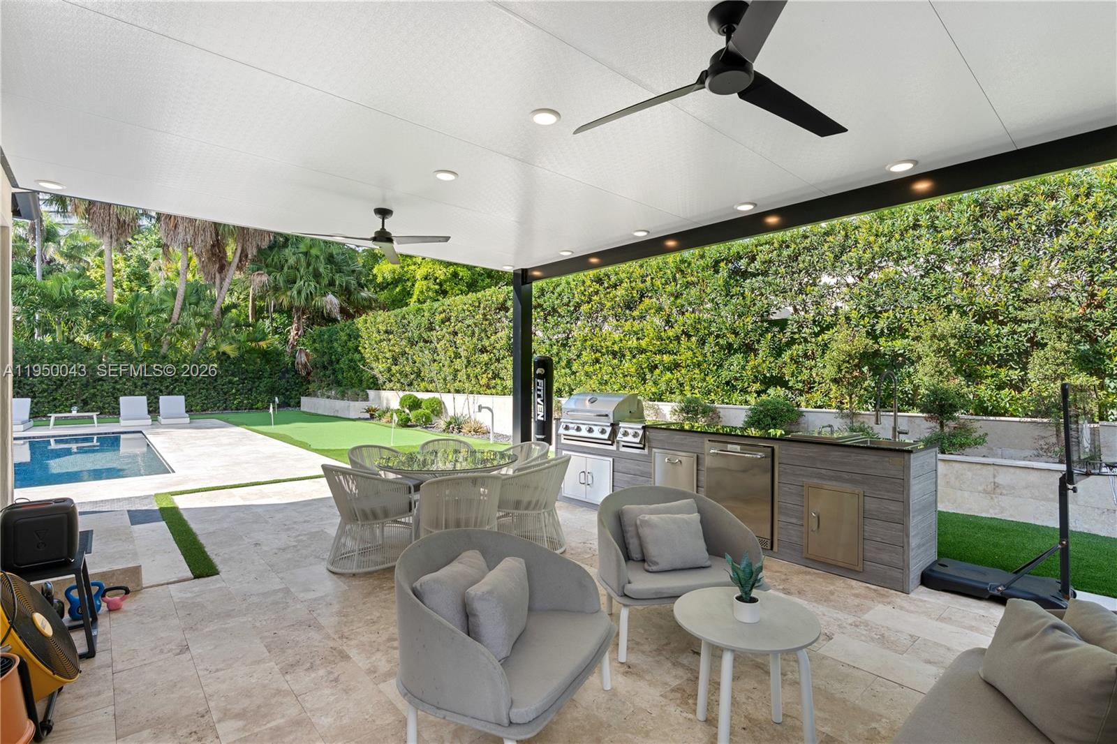 7345 Southwest 96th Street Pinecrest, FL 33156 - Photo 18 of 62 a patio with yard table and chairs