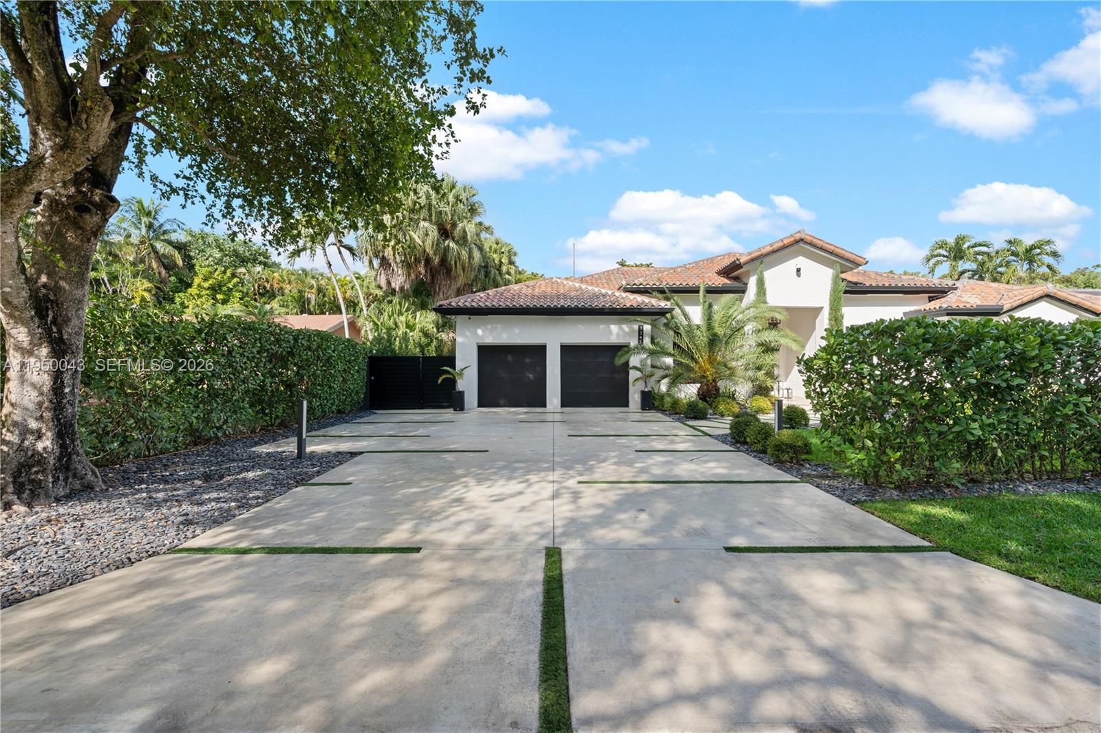 7345 Southwest 96th Street Pinecrest, FL 33156 - Photo 2 of 62 a front view of a house with yard garage and outdoor seating