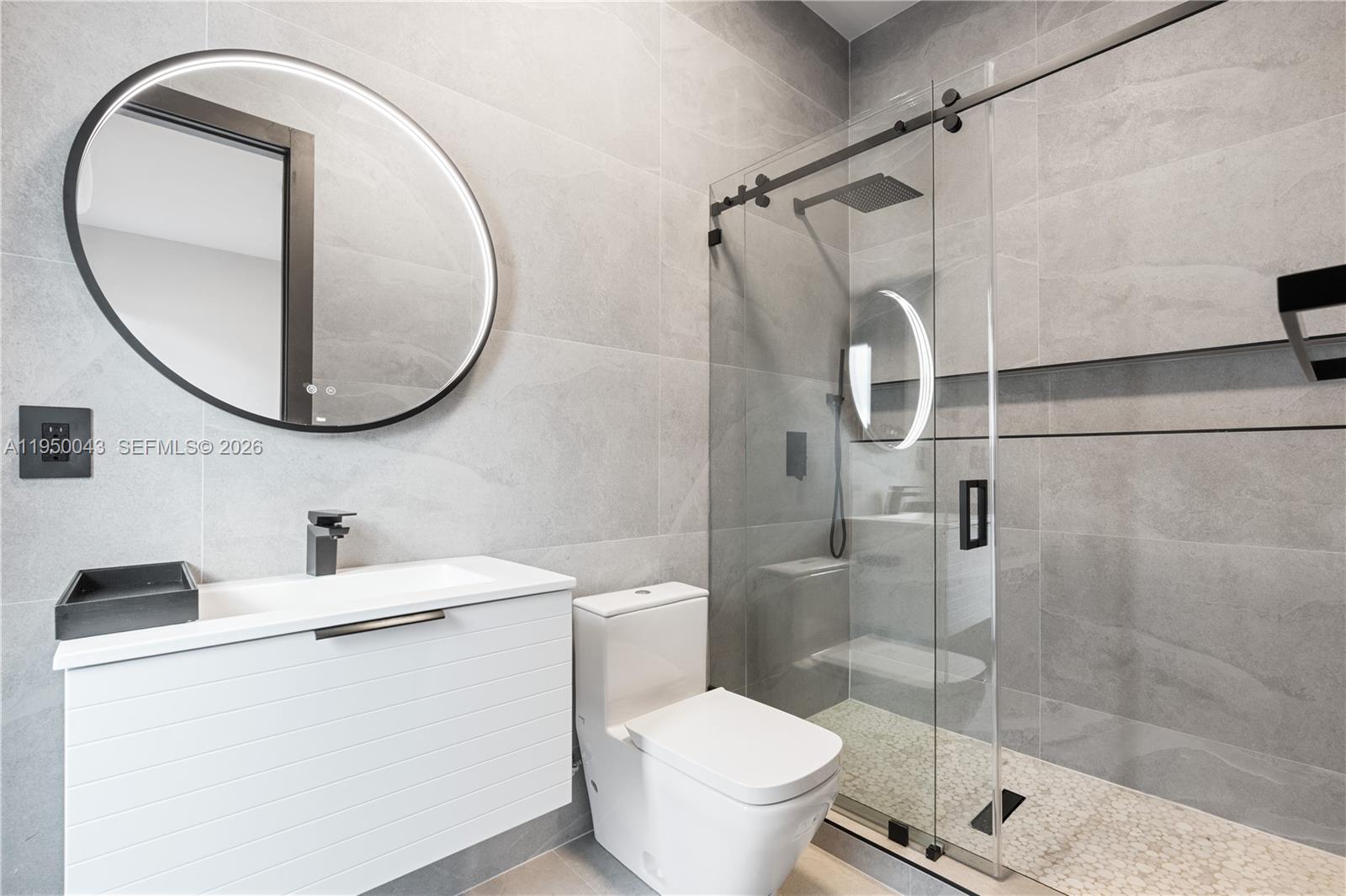 7345 Southwest 96th Street Pinecrest, FL 33156 - Photo 43 of 60 a bathroom with a sink toilet and a mirror