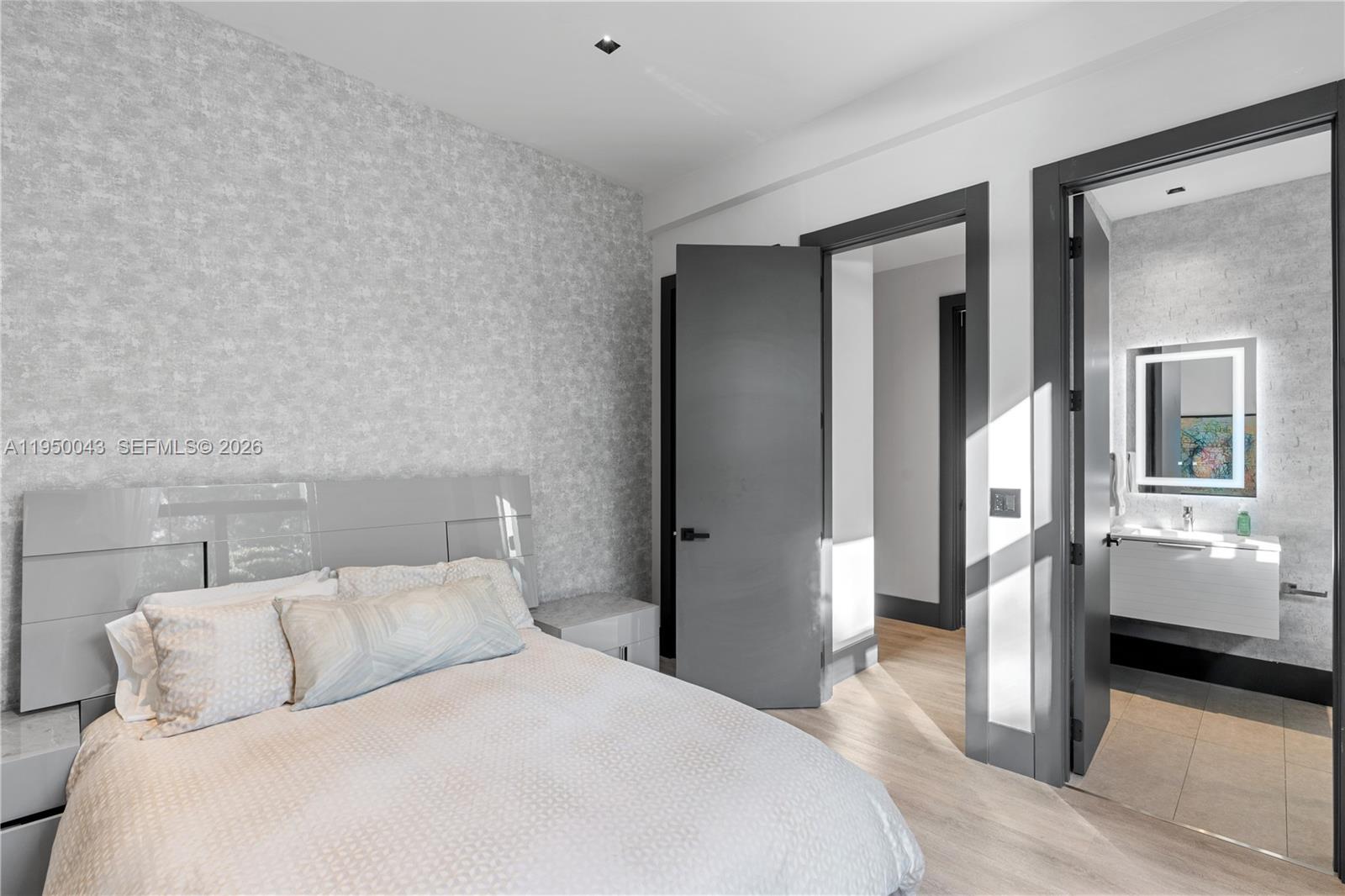 7345 Southwest 96th Street Pinecrest, FL 33156 - Photo 47 of 60 a bedroom with a large bed and a chandelier