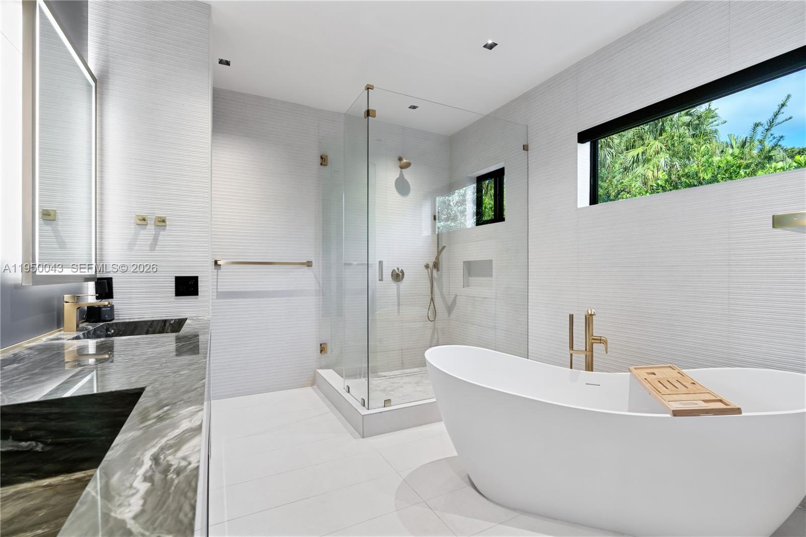 7345 Southwest 96th Street Pinecrest, FL 33156 - Photo 58 of 60 a bathroom with a tub a sink a window and a shower