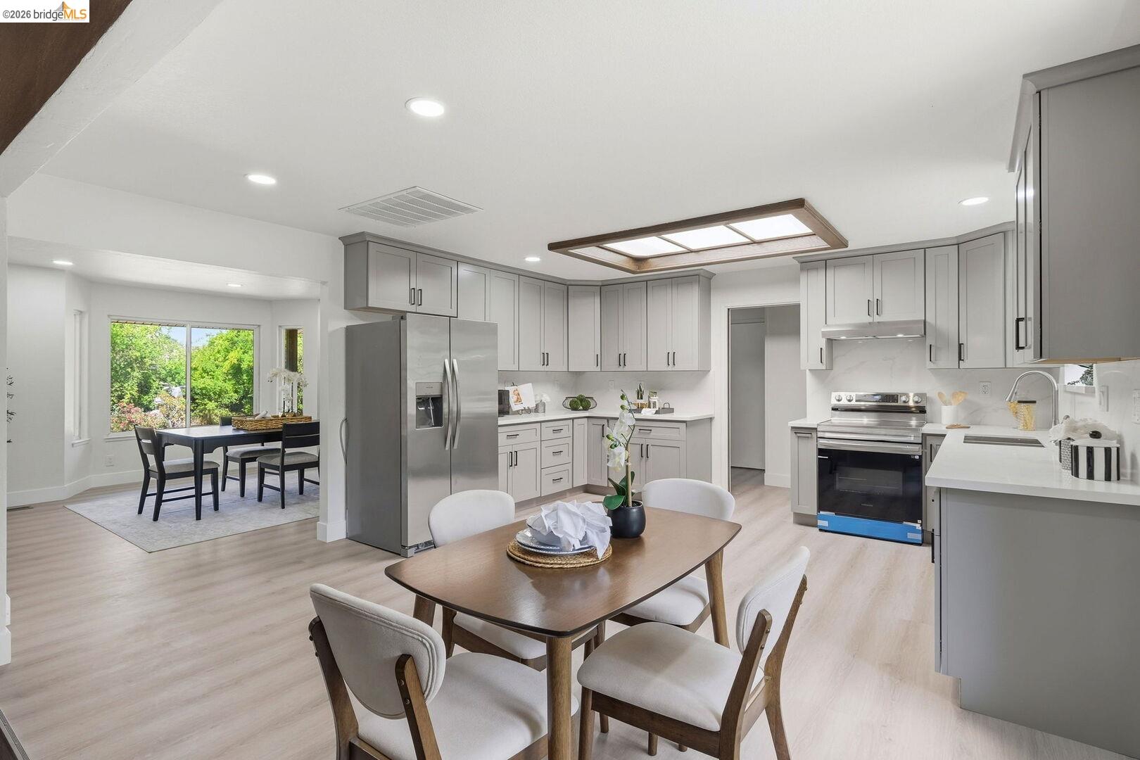 1590 Sunset Road Brentwood, CA 94513 - Photo 12 of 45 Open-concept kitchen featuring light-toned wood-finish flooring, recessed lighting, a bay window dining area, stainless steel appliances, and abundant cabinet storage