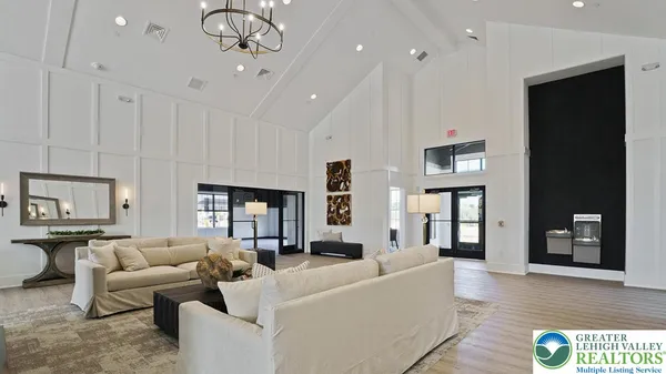 a living room with a table a rug and kitchen view