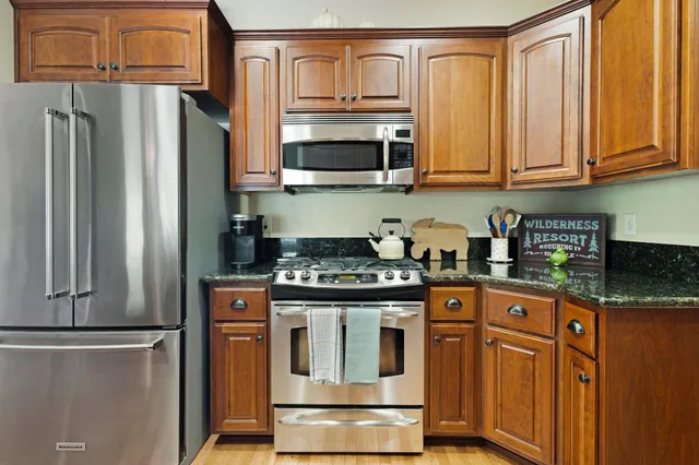 a kitchen with stainless steel appliances granite countertop a refrigerator stove and microwave