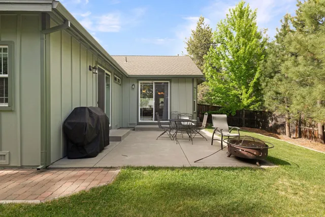 a view of a backyard with table and chairs and a barbeque