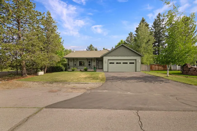 a view of house with yard and tree in front of it
