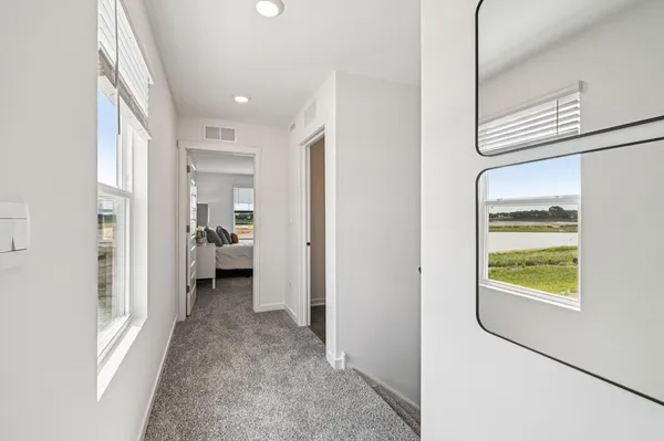 a view of a hallway with a livingroom and a bathroom