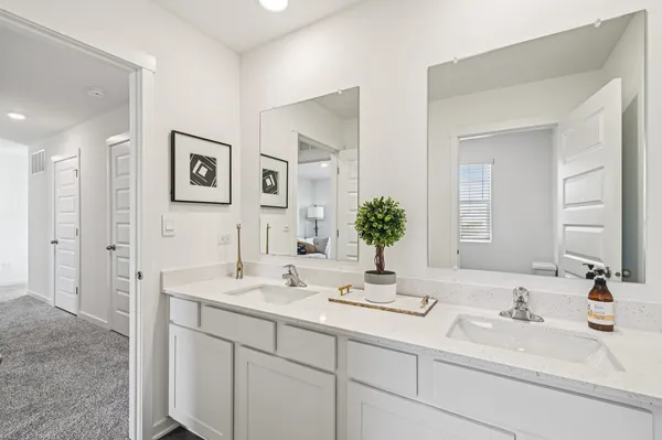 a bathroom with double vanity sinks and a mirror