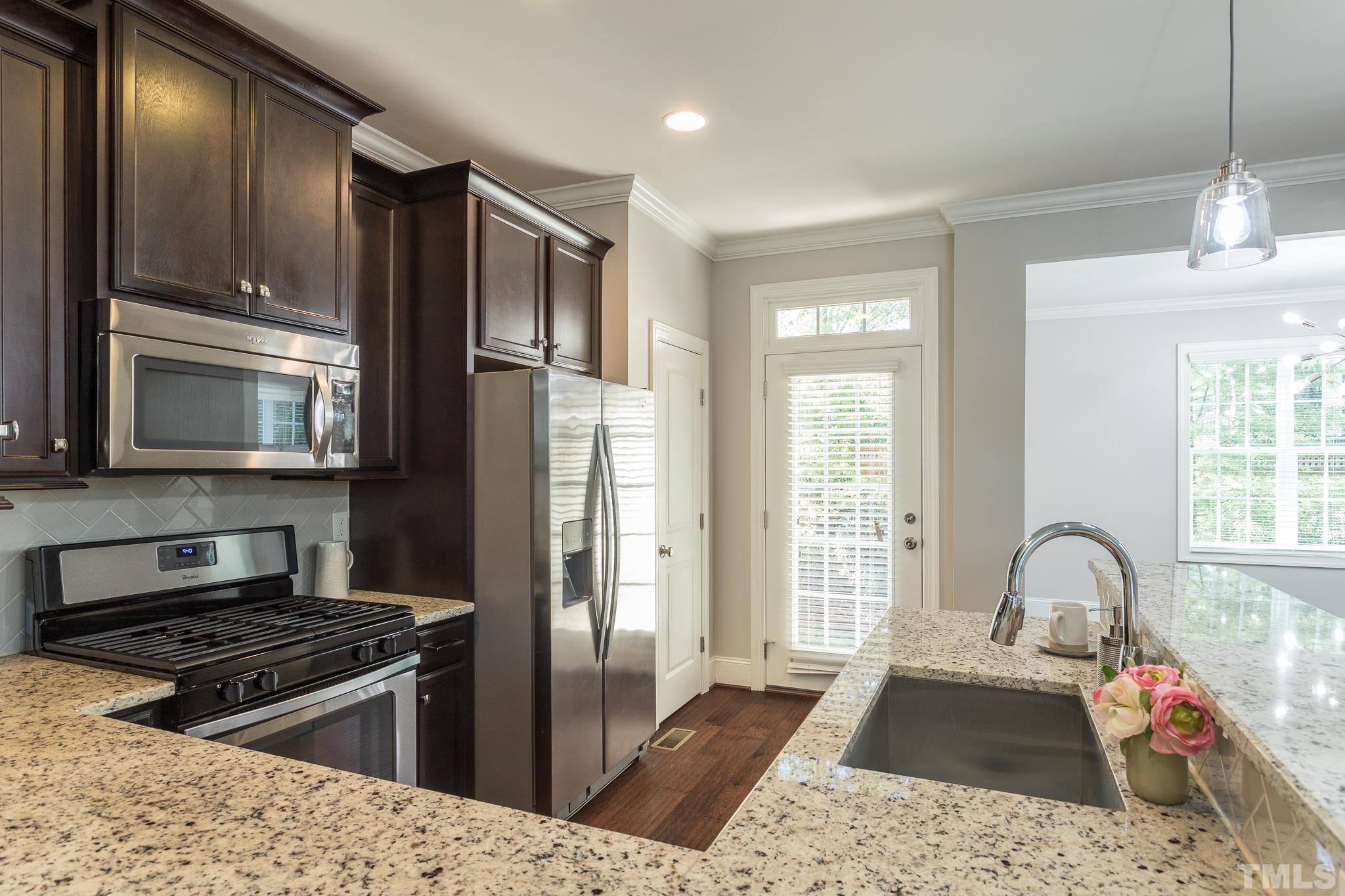 2809 Plumfield Place Raleigh, NC 27607 - Photo 2 of 25 a kitchen with stainless steel appliances granite countertop a stove a sink and a refrigerator