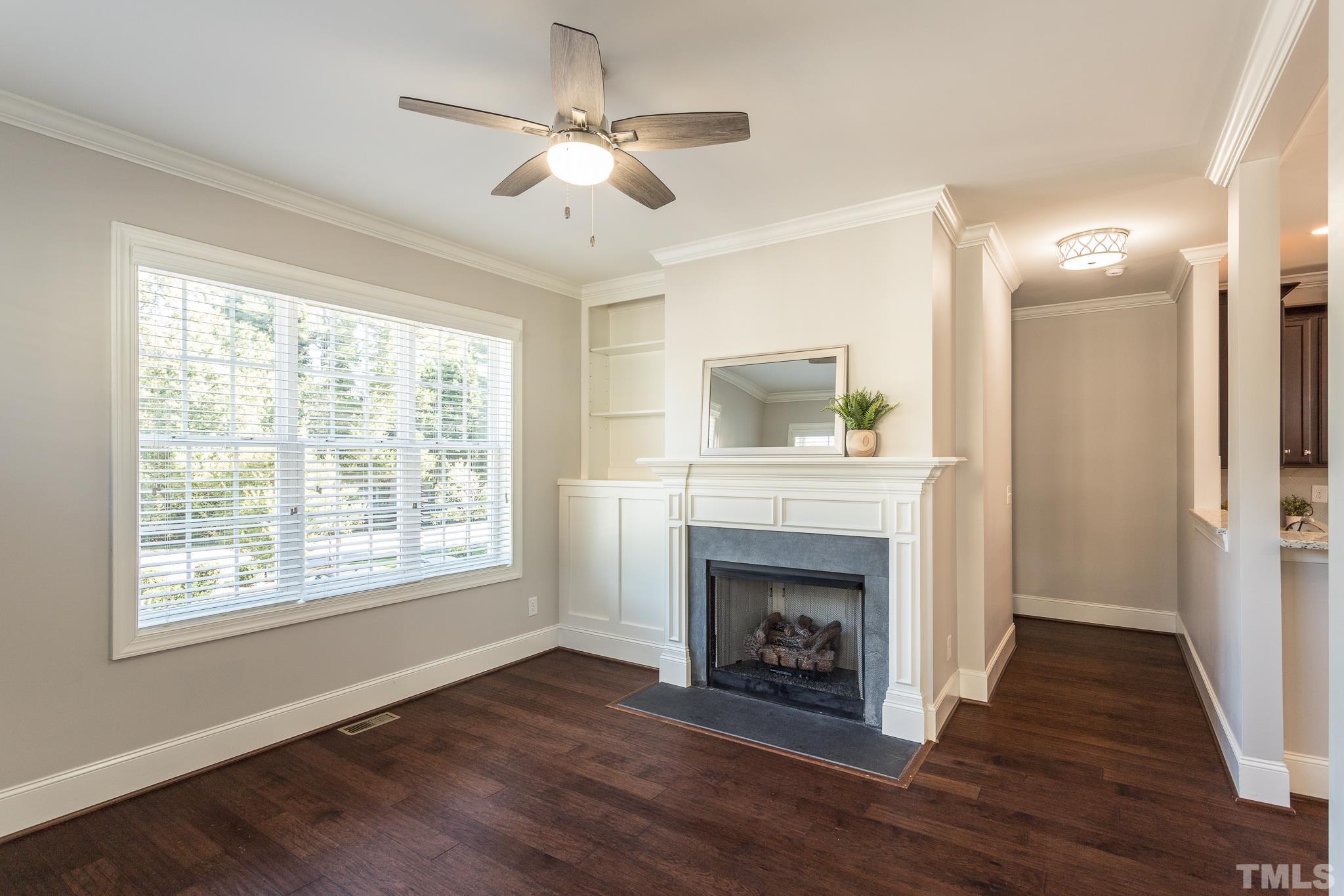 2809 Plumfield Place Raleigh, NC 27607 - Photo 3 of 25 a view of an empty room with wooden floor fireplace and a window