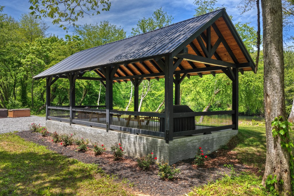 Lot 5 Grassy Creek Road Copperhill, TN 37317 - Photo 8 of 30 a view of a patio with table and chairs under an umbrella with a big yard