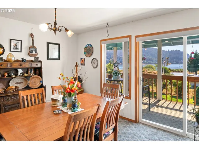 a view of a dining room with furniture a chandelier and large windows
