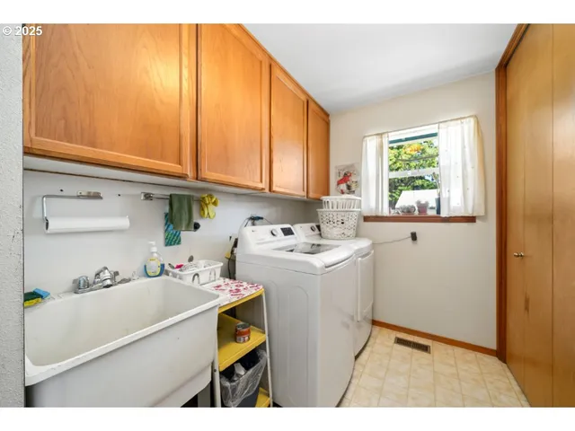 a utility room with cabinets washer and dryer