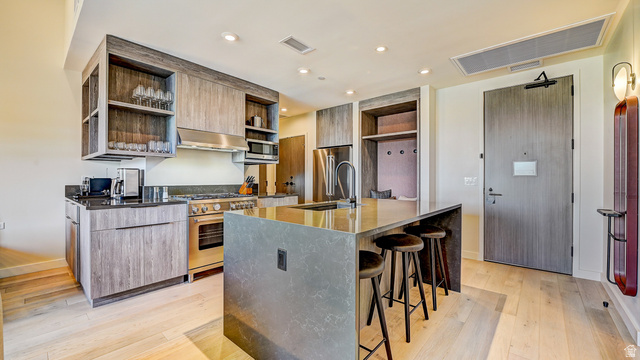 2417 West High Road, Unit 2515 Park City, UT 84098 - Photo 12 of 67 Kitchen with modern cabinets, open shelves, dark stone countertops, premium appliances, and light wood-style flooring