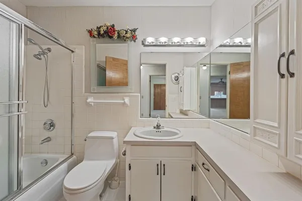 a bathroom with a sink a toilet a mirror and shower