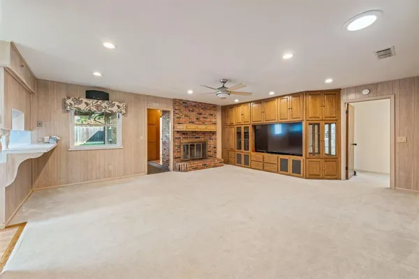 a view of an empty room with a window and fireplace
