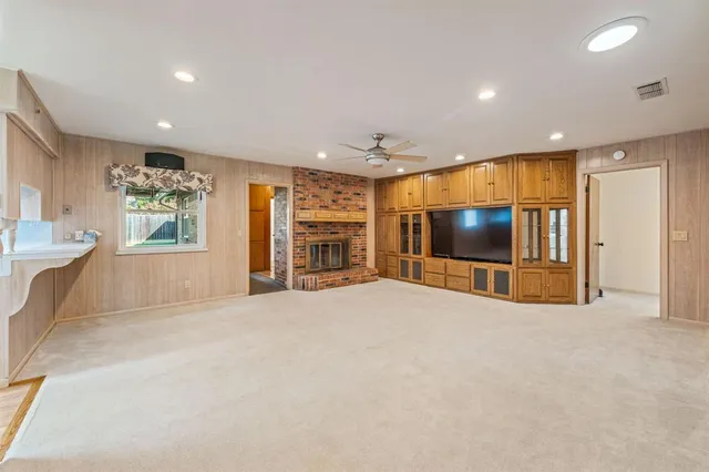 a view of an empty room with a window and fireplace