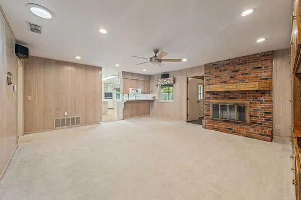 an empty room with a fireplace and a kitchen