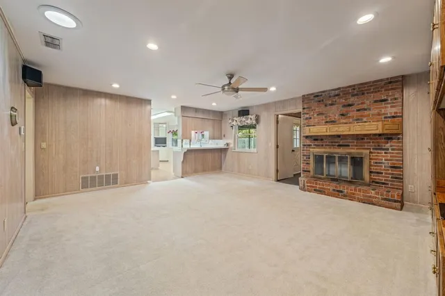 an empty room with a fireplace and a kitchen