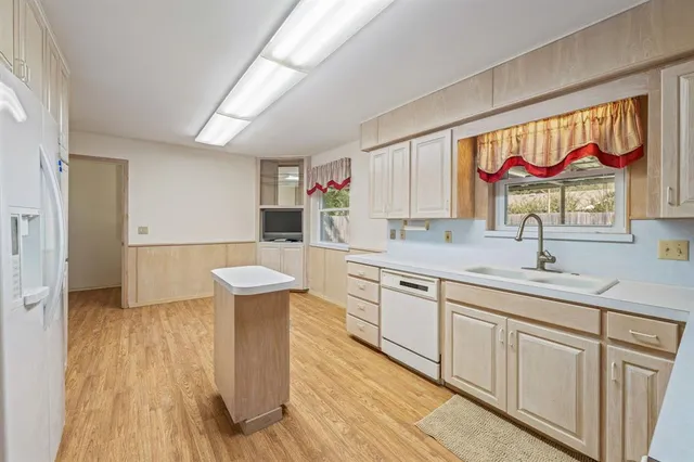 a kitchen with stainless steel appliances a stove a sink dishwasher and a wooden cabinets