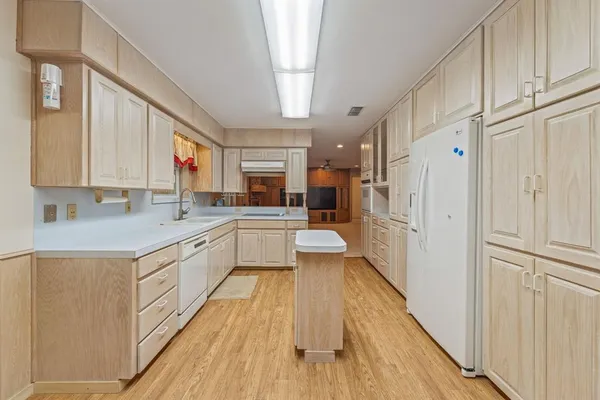 a large white kitchen with a large window