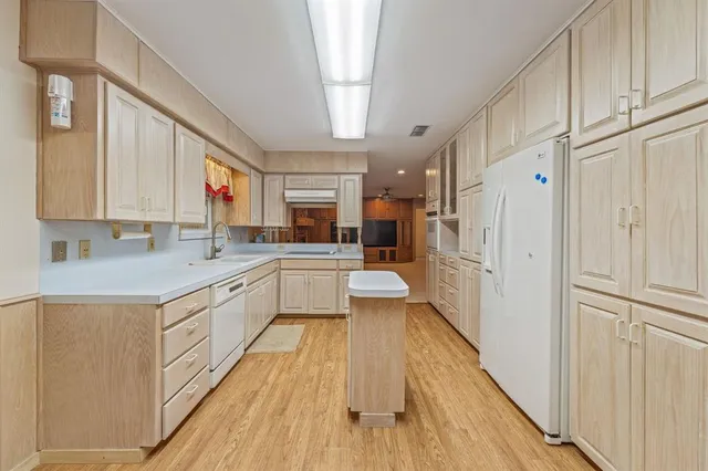 a large white kitchen with a large window