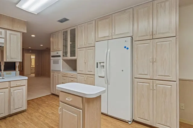 a kitchen with white cabinets and refrigerator