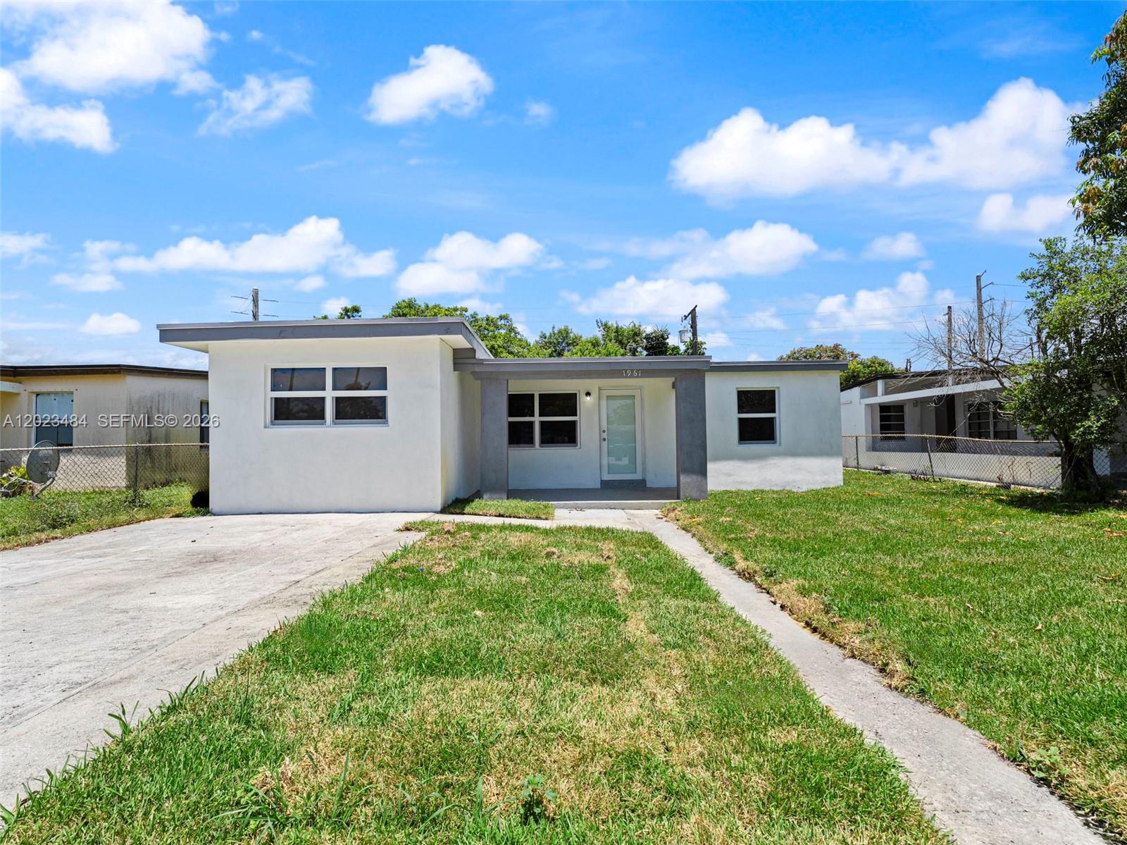 1961 Rutland Street Opa-Locka, FL 33054 - Photo 2 of 33 a front view of a house with a garden