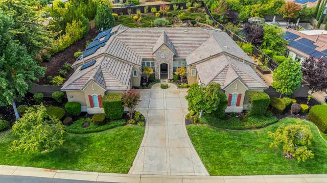 a aerial view of a house with a yard and potted plants