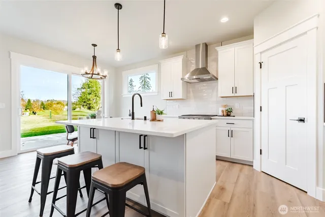 a kitchen with stainless steel appliances a table chairs refrigerator and sink