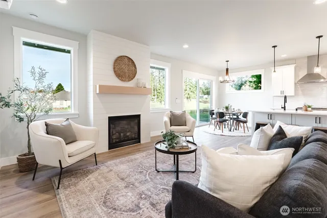 a living room with furniture a fireplace and a large window