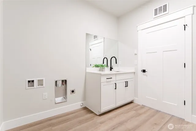 a room with a sink cabinets and a wooden floor