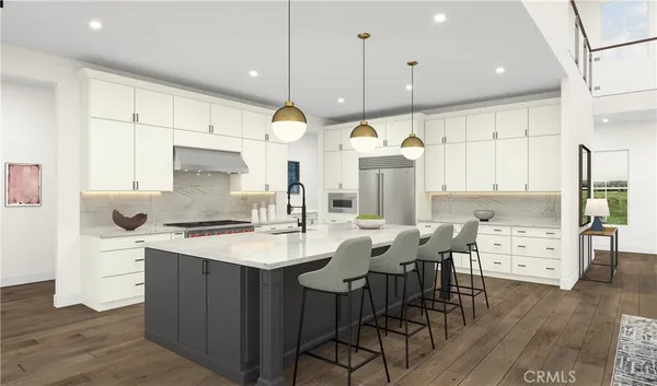 a kitchen with stainless steel appliances kitchen island a table chairs in it and wooden floors