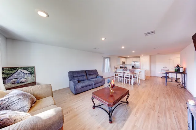 a living room with furniture and a wooden floor