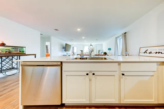a kitchen with stainless steel appliances cabinets and wooden floor