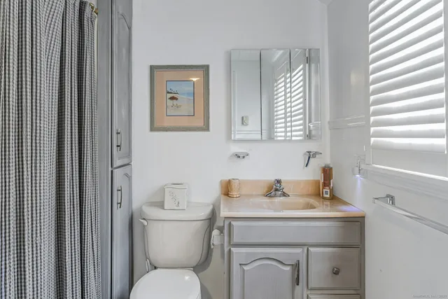 a bathroom with a toilet a sink and a mirror