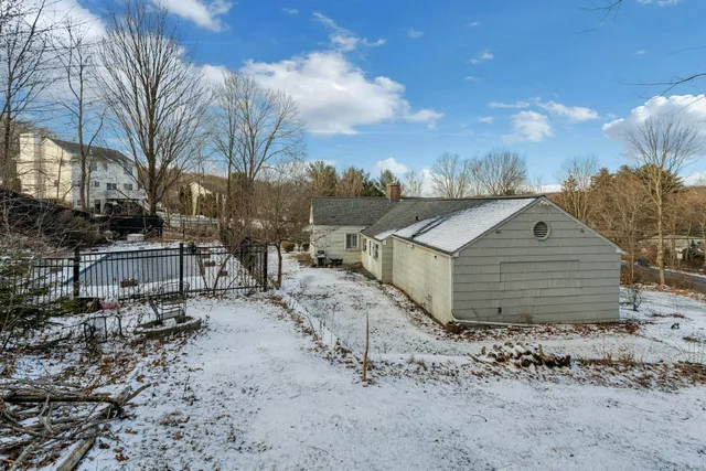 a view of a white house with a yard covered in snow