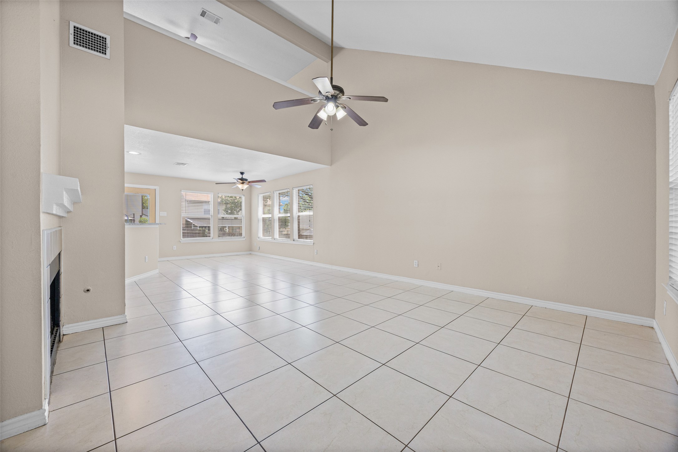 2432 Roundabout Lane Round Rock, TX 78664 - Photo 3 of 22 Vast tile flooring guides guests through this luminous living space, crowned by vaulted ceilings and inviting windows.