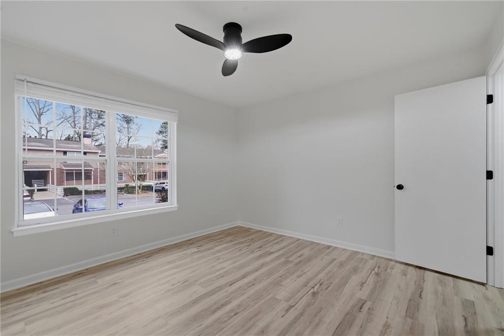 256 Quail Run, Unit 256 Roswell, GA 30076 - Photo 12 of 33 a view of an empty room with a window and wooden floor