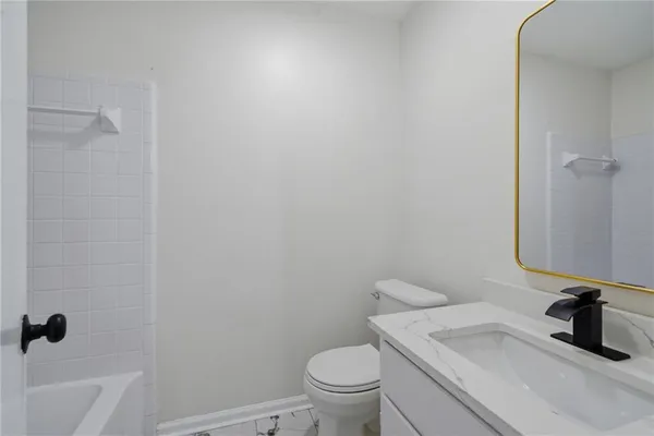 a bathroom with a granite countertop toilet and a sink