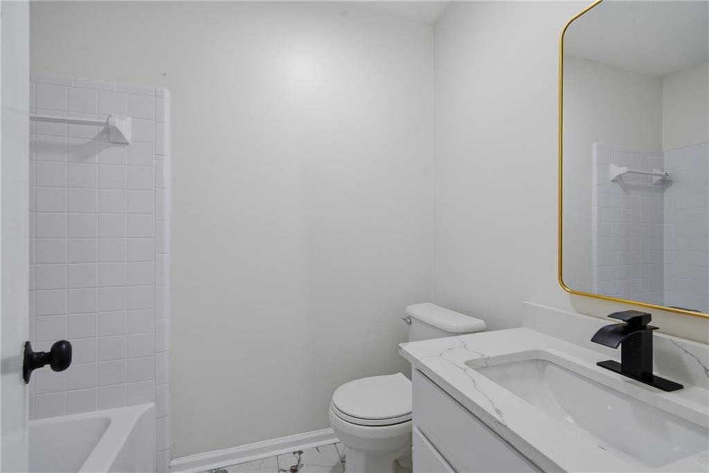 256 Quail Run, Unit 256 Roswell, GA 30076 - Photo 14 of 33 a bathroom with a granite countertop toilet and a sink