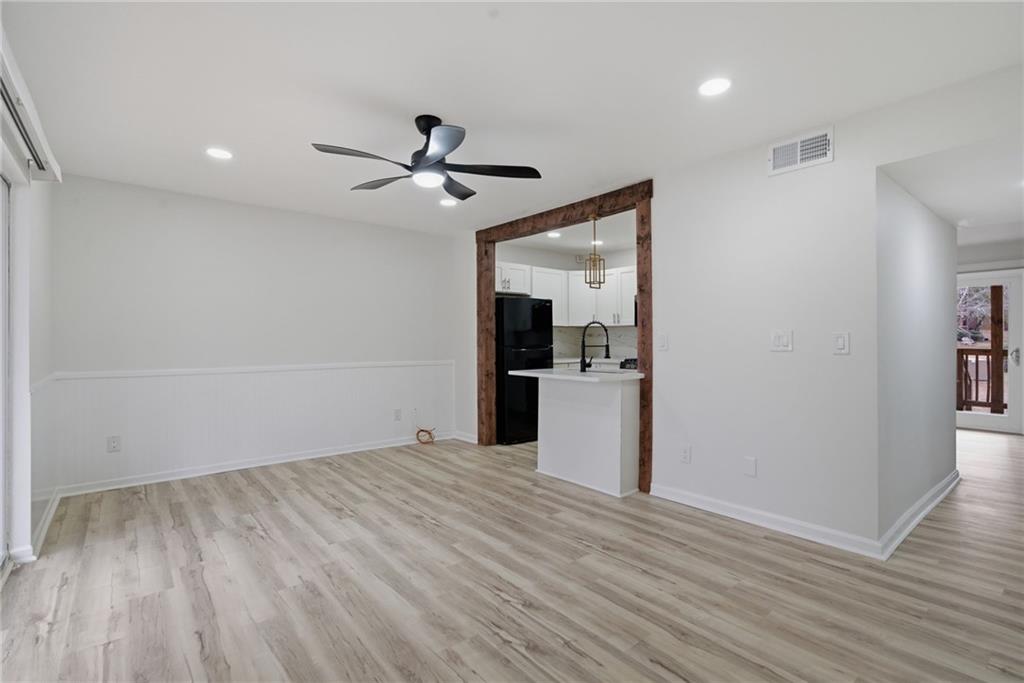 256 Quail Run, Unit 256 Roswell, GA 30076 - Photo 5 of 33 a view of empty room with wooden floor and kitchen view