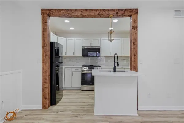 a kitchen with stainless steel appliances granite countertop a stove top oven a sink and a refrigerator