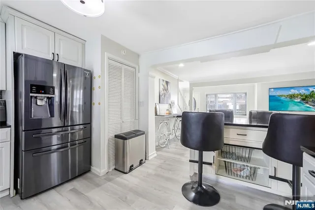 a kitchen with stainless steel appliances granite countertop a refrigerator and a chair