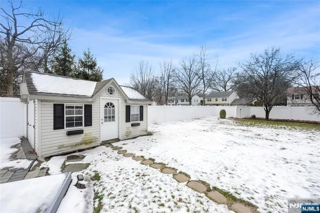 a view of a yard covered with snow in front of house