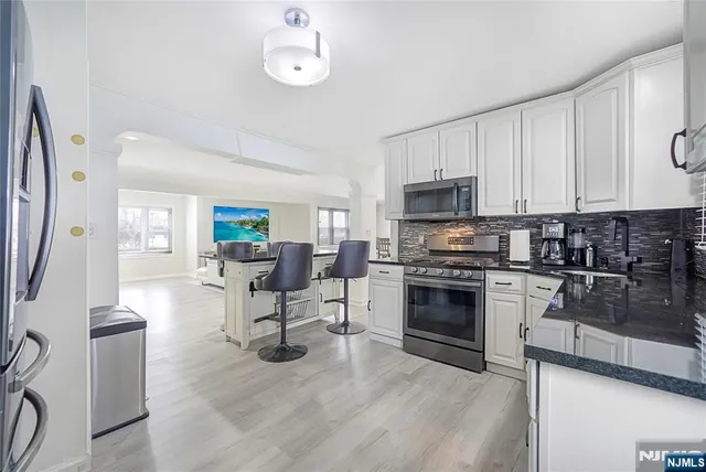 a kitchen with stainless steel appliances a stove a sink a microwave and cabinets