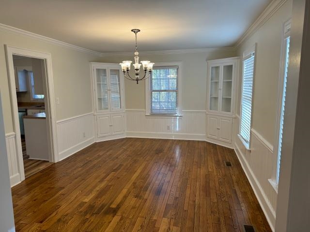 1409 Roper Road Bolivar, TN 38008 - Photo 11 of 33 Unfurnished dining area featuring crown molding, dark wood-type flooring, and an inviting chandelier